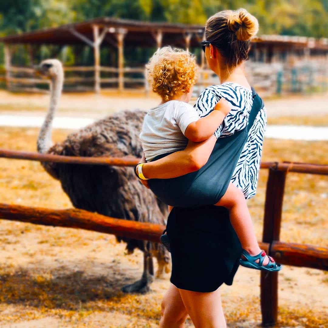 Mutter trägt ein Kind am See